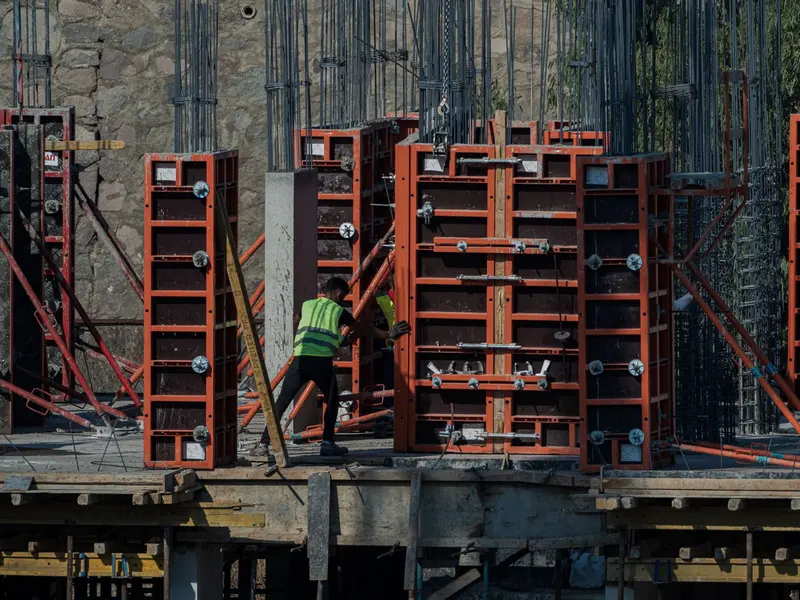 Radnik slaže metalnu oplatu za betonske zidove na gradilištu